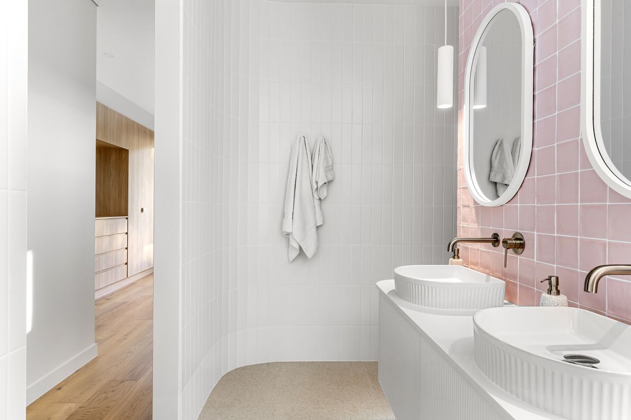 creative-approach-img Elegant minimalist bathroom featuring pink tiles and dual sinks with modern fixtures.